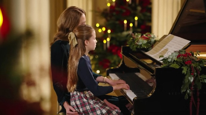 Vlasy měla Charlotte - k dotvoření vánoční atmosféry - napůl sepnuté zlatou mašlí.