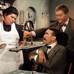 Dobrý voják Švejk: Josef Švejk - obchodník se psy a člověk s diagnózou notorického blba, který je zatčen po sarajevském atentátu a později povolán do armády. Na snímku jsou Olga Karásková, František Filipovský a Rudolf Hrušínský.