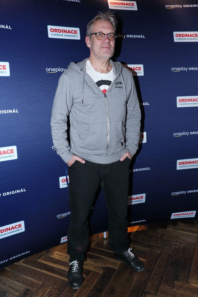 Pře bílé tričko oblékl herec ještě šedou mikinu. 