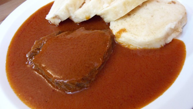 Rajská omáčka

Suroviny:

600 g hovězí plece
150 g špeku
600 g kořenové zeleniny
100 g cibule
divoké koření (pepř, nové koření, bobkový list)
malý kousek celé skořice (podle chuti i čtyři hřebíčky)
100 ml oleje
lžíce cukru
200 g rajského protlaku
1200 ml masového vývaru
sůl
pepř
80 g másla
citronová šťáva

Postup:

Maso vcelku prošpikujeme proužky slaniny (1/3 z celkového množství), můžeme protknout i kusy zeleniny (též 1/3 množství), osolíme a opepříme.

Na rozpáleném oleji orestujeme maso ze všech stran, vyjmeme. Do téhož kastrolu s výpekem vložíme na kostičky pokrájený špek, vypečeme dorůžova, přidáme zeleninu a orestujeme do zlatohněda, vložíme koření, zasypeme cukrem, zarestujeme, přidáme rajský protlak, zarestujeme, zalijeme vývarem, vložíme maso a kousek celé skořice (event. hřebíček), přiklopíme a dusíme doměkka na sporáku či v předem vyhřáté troubě.

Když je maso měkké, vyjmeme jej, nakrájíme, omáčku propasírujeme, zjemníme máslem, dochutíme citronovou šťávou. Podáváme s houskovým knedlíkem.