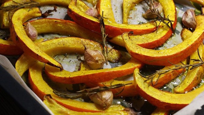 Dýně na rozmarýnu a česneku:
Suroviny:
1 větší dýně Hokkaido
slunečnicový olej
½ palice česneku
rozmarýn
sůl a pepř.
Postup:
Neoloupanou dýni Hokkaido vydlabeme a nakrájíme na plátky asi 1 cm tlusté. Dýni Hokkaido smícháme s olejem, solí a pepřem a rozprostřeme na plech vyložený pečicím papírem. Rovnoměrně rozmístíme snítky rozmarýnu a celé (neoloupané) stroužky česneku. Pečeme v troubě rozehřáté na 200 °C asi 45 minut dozlatova. Česnek a rozmarýn odstraníme (nadrobno nakrájené kousky rozmarýnu můžeme v pokrmu nechat).