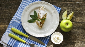 Jablečný štrúdl
Suroviny:
1 balení listového těsta
4 jablka
3 lžíce skořicového cukru
1 vejce
hrst rozinek
hrst loupaných vlašských ořechů
hrst strouhanky
voda podle potřeby
Postup:
Do malé misky nasypeme rozinky a zalijeme je trochou vody. Rozinky necháme nabobtnat.
Jablka opláchneme a osušíme. Rozkrojíme je na čtvrtky a zbavíme jadřinců. Každý kus vezmeme a nastrouháme na hrubo. Kousky jablek strouháme tak, aby nám zůstala slupka v ruce. To nám ušetří práci s loupáním.
Ořechy dáme do sáčku a paličkou na maso nebo válečkem je rozdrtíme. Listové těsto rozválíme. Pokud máte menší pekáč, těsto klidně rozdělte na více dílů.
Na rozpálené pánvi opražíme strouhanku a posypeme s ní plát listového těsta. Následně na něj poklademe nastrouhaná jablka, nasypeme oříšky a rozinky. Vše ochutíme skořicovým cukrem.
Předehřejeme si troubu na 180 °C a plech vyložíme pečicím papírem. Jablečný štrúdl dobře zabalíme a na krajích zpevníme. V misce rozšleháme vajíčko a štrúdl s ním potřeme. Pečeme jej ve vyhřáté troubě asi 20 až 25 minut dozlatova.
Smetanu šleháme tak dlouho, dokud není pevná a tuhá. Hotový štrúdl posypeme moučkovým cukrem a podáváme se šlehačkou.