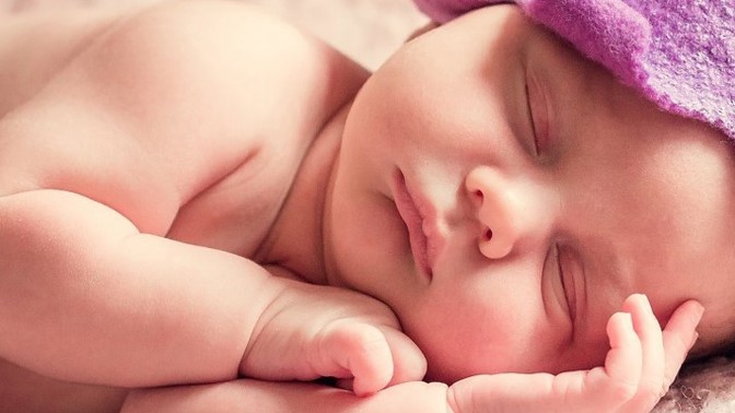 Miminko obklopené jehlami. Netradiční fotka symbolizuje strastiplný boj lesbického páru o děťátko