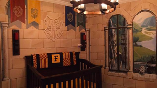 Nad postýlkou visí vlajky všech čtyř bradavických kolejí.