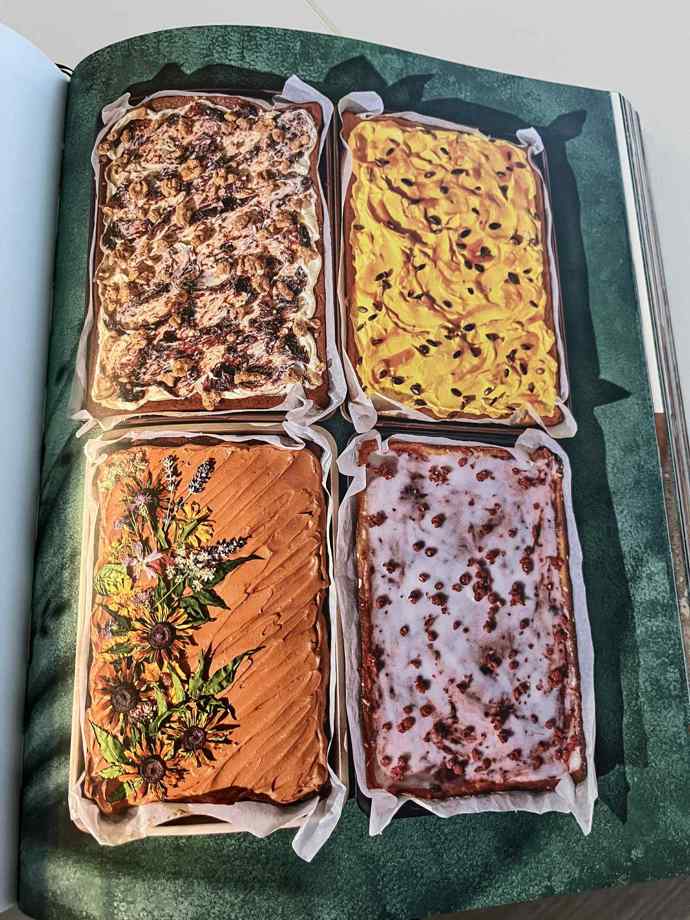 Vlevo dole vidíme čokoládovou kefírovou buchtu s kávou, která je dekorovaná sušenými jedlými květy. 