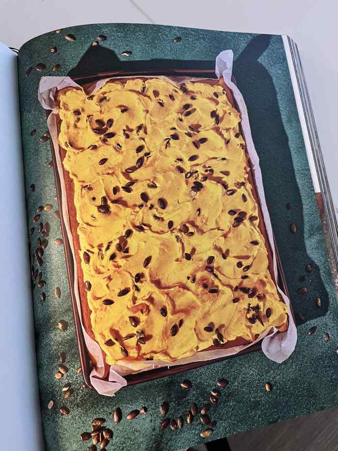 Dýňová kefírová buchta s kořením, posypaná dýňovými semínky. 