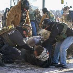 Agenti ICE zatýkají protestujícího.