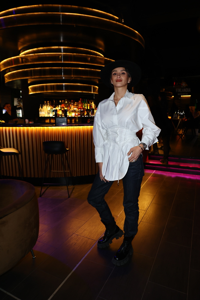 Košili doplnila úzkými džínami a černým kloboukem. 