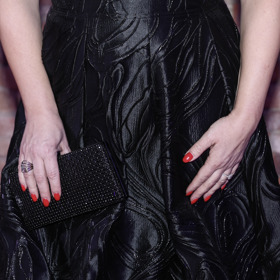 Červené nehty operní pěvkyně se na černých šatech zvlášť vyjímaly.