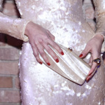 Modelka červené nehty doladila k něžným perleťovým šatům i psaníčku.