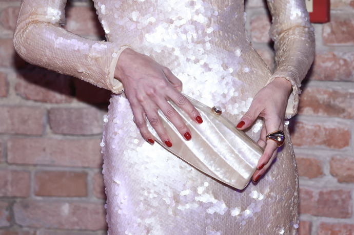 Modelka červené nehty doladila k něžným perleťovým šatům i psaníčku.