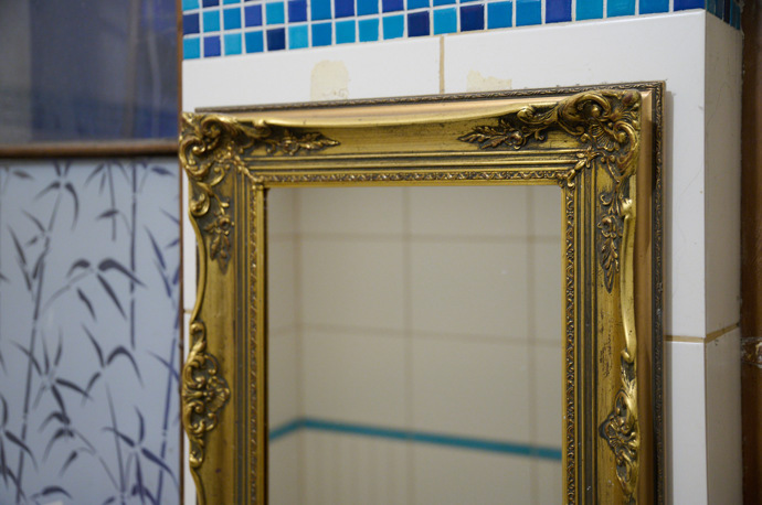 V koupelně je zrcadlo v krásném starožitném rámu