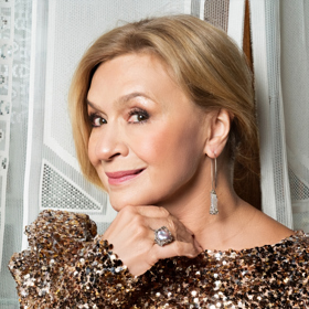 Visací náušnice a velký prsten nelze přehlédnout.