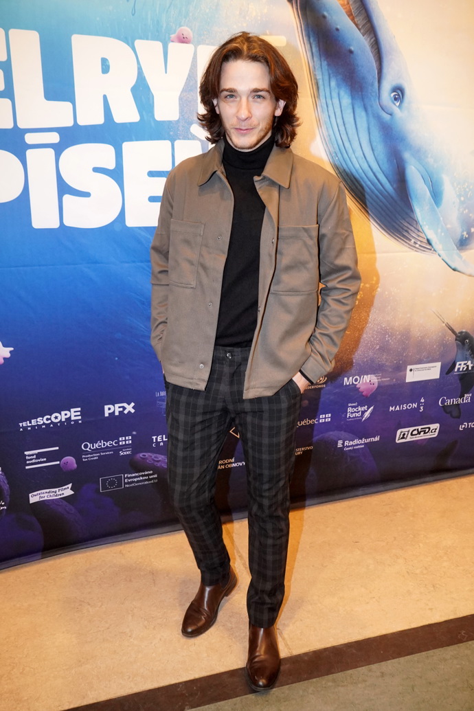 Tomáš Weber oblékl kostkované tmavě šedé kalhoty, černý rolák a khaki bundu.