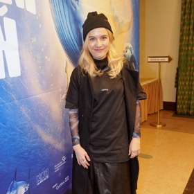 Tereza Ramba předvedla zajímavou variaci na vrstvení. Základem je černá kožená sukně, přes kterou má herečka černé sako a černé tričko ze svého vlastního merche. Nechybí černá čepice a elastické triko s dlouhým rukávem. 