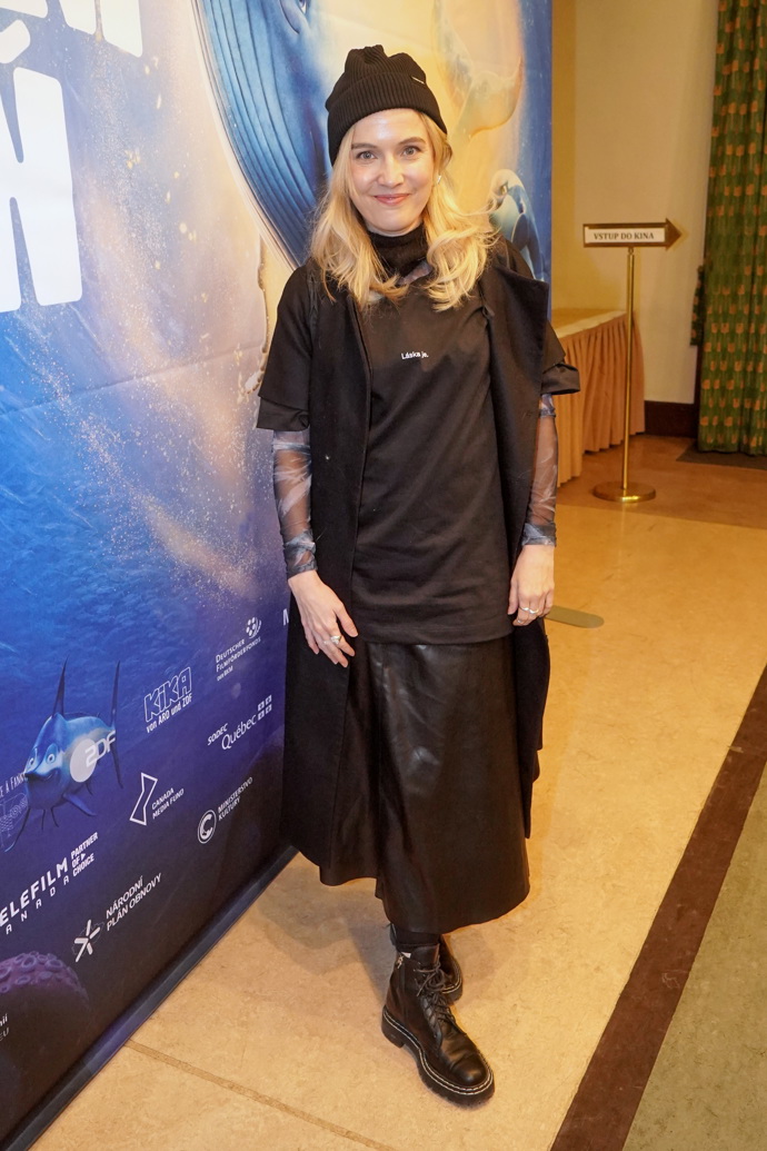 Tereza Ramba předvedla zajímavou variaci na vrstvení. Základem je černá kožená sukně, přes kterou má herečka černé sako a černé tričko ze svého vlastního merche. Nechybí černá čepice a elastické triko s dlouhým rukávem. 