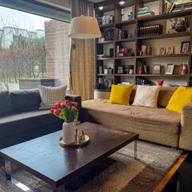 Do domu krásně prostupuje světlo skrze prosklenou stěnu v obýváku.