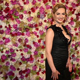 Hana Kynychová pózovala před květinovou stěnou.