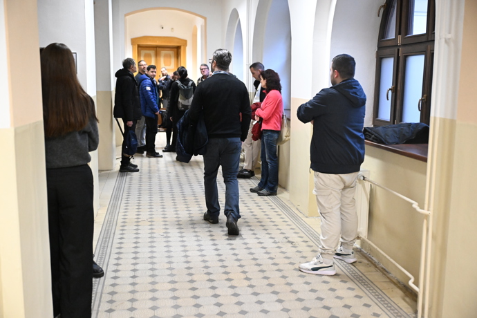 Někteří lidé čekali před soudní místností. 