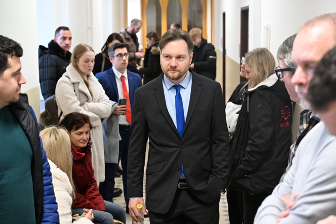 Před soudní místností bylo rušno. 