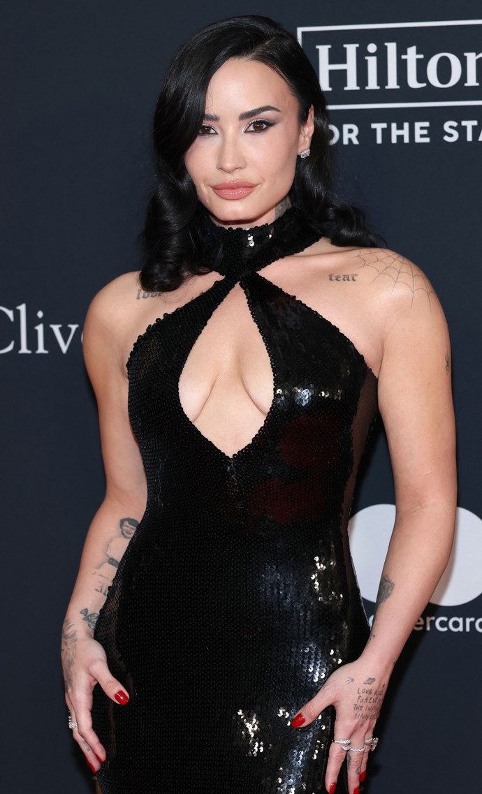 Demi Lovato vynesla na letošní ročník Grammy černé flitrové šaty s výstřihem, který jí příliš nelichotil a vnady utiskoval.