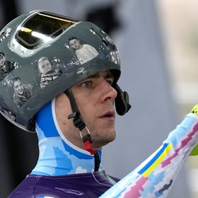 Vladyslav Heraskevyč vynesl helmu s fotkami mrtvých sportovců.