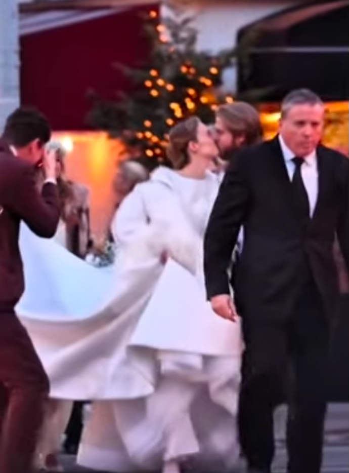 Nevěsta zvolila netradiční zimní outfit, přes bílé šaty přehodila i masivní péřový kabát.