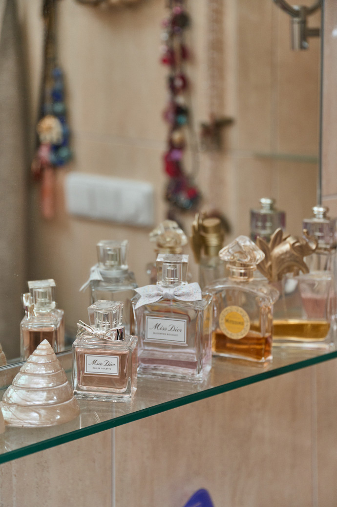Na poličce pod zrcadlem je řada parfémů.