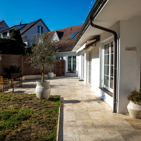 Pohled ze strany a v pozadí původní domeček 1 plus 1, který si Veronika Žilková koupila v Suchdole.