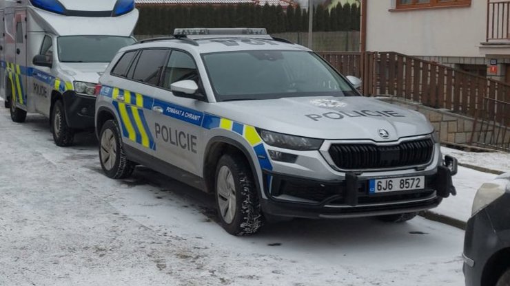 Policisté a hasiči před domem v Třešti, kde se stala vražda.