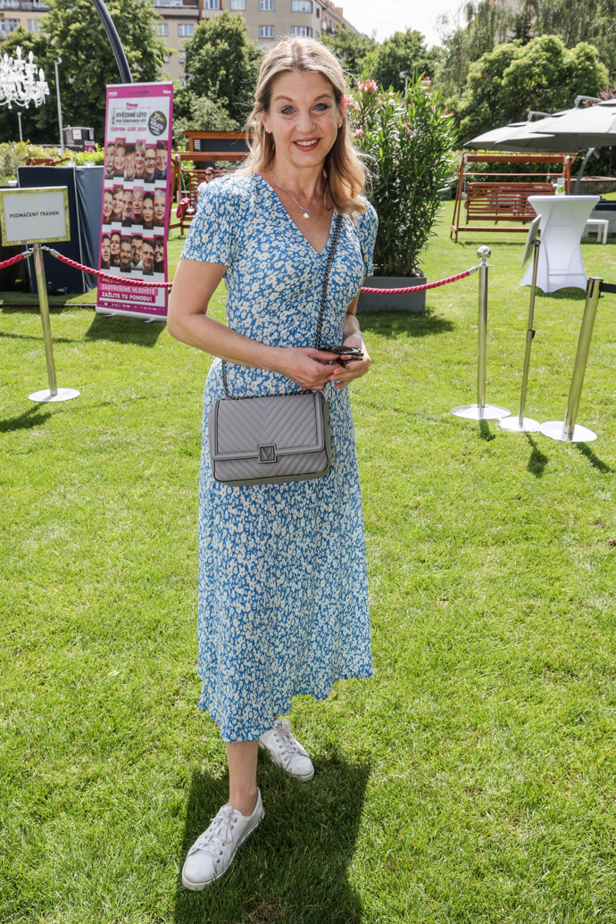 Ke květovaným šatům nazouvá Sabina Laurinová i mladistvé bílé tenisky.