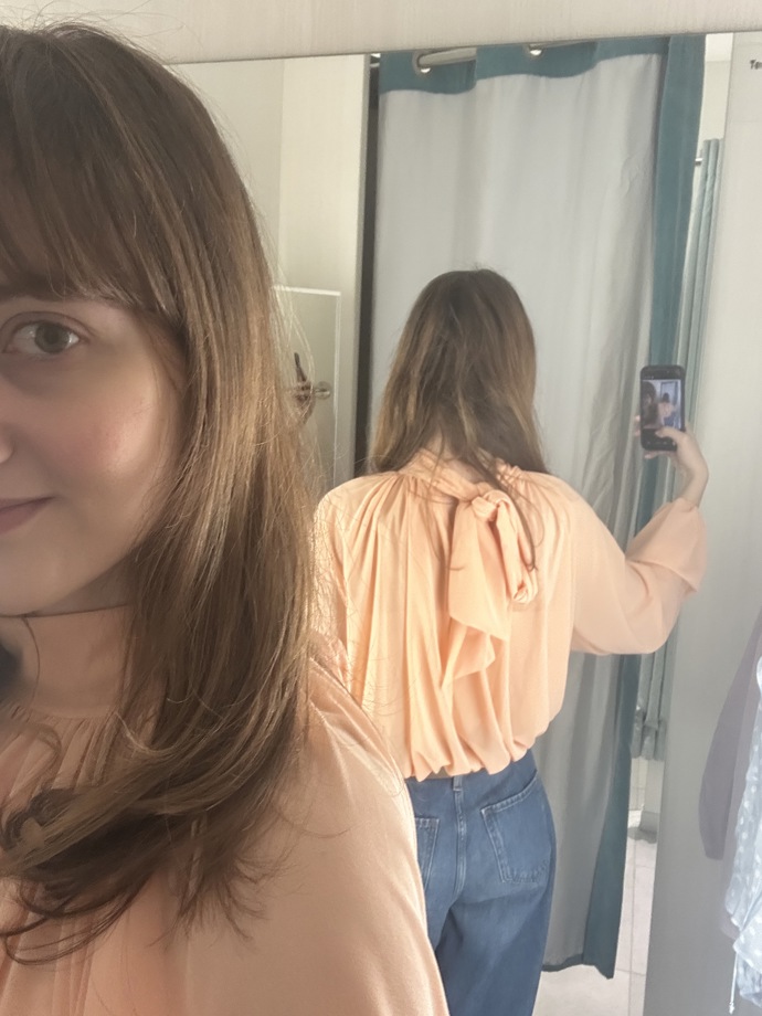 Zatímco vepředu je halenka velmi decentní, vzadu má vázání na mašli. Halenka stojí 619 Kč