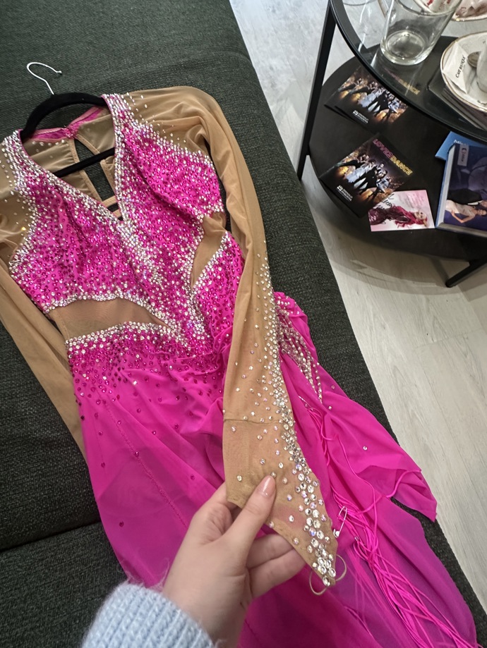 Šaty vytvářejí iluzi nahých paží, ve skutečnosti mají rukávy z tělové síťky ozdobené kamínky.