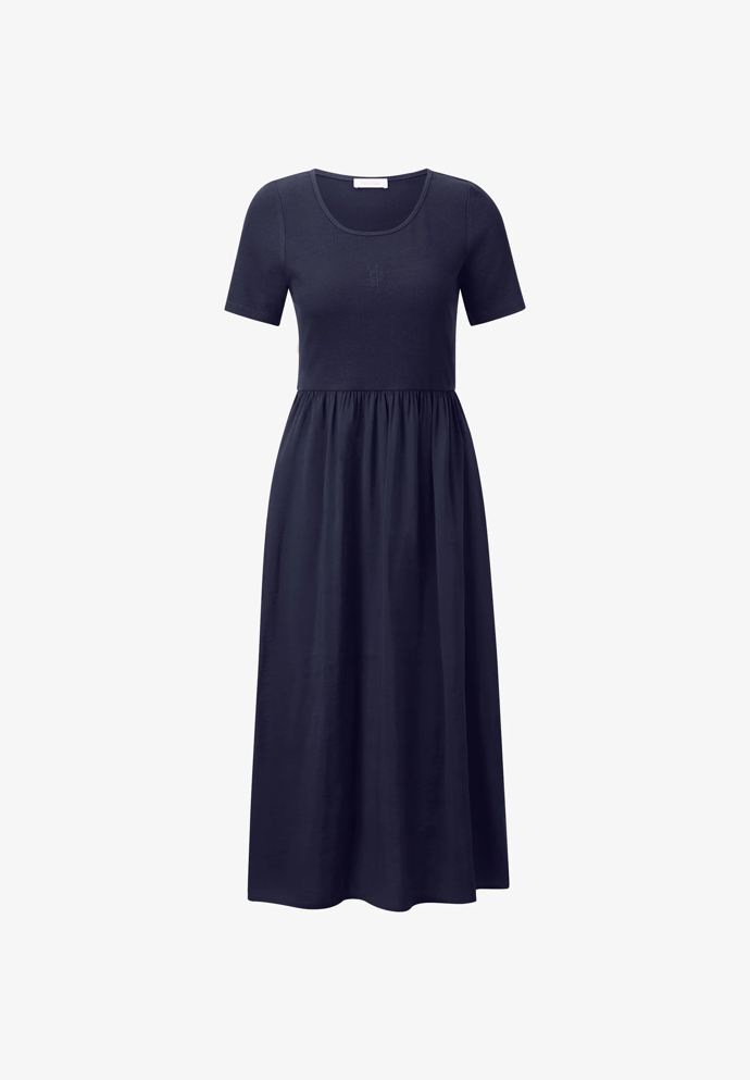 Základ outfitu Sabiny Remundové tvořily tmavomodré midi šaty, které si přímo říkají o zajímavý doplněk, jenž je ozvláštní. Tento model je od značky Rich & Royal a stojí 3500 Kč.