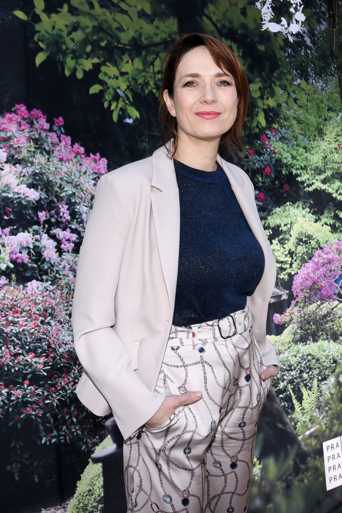 Hereččin look pak doplnilo univerzální sako v ladícím neutrálním odstínu a kontrastní tmavomodrý top, který dokonale pasoval ke vzoru na kalhotách.