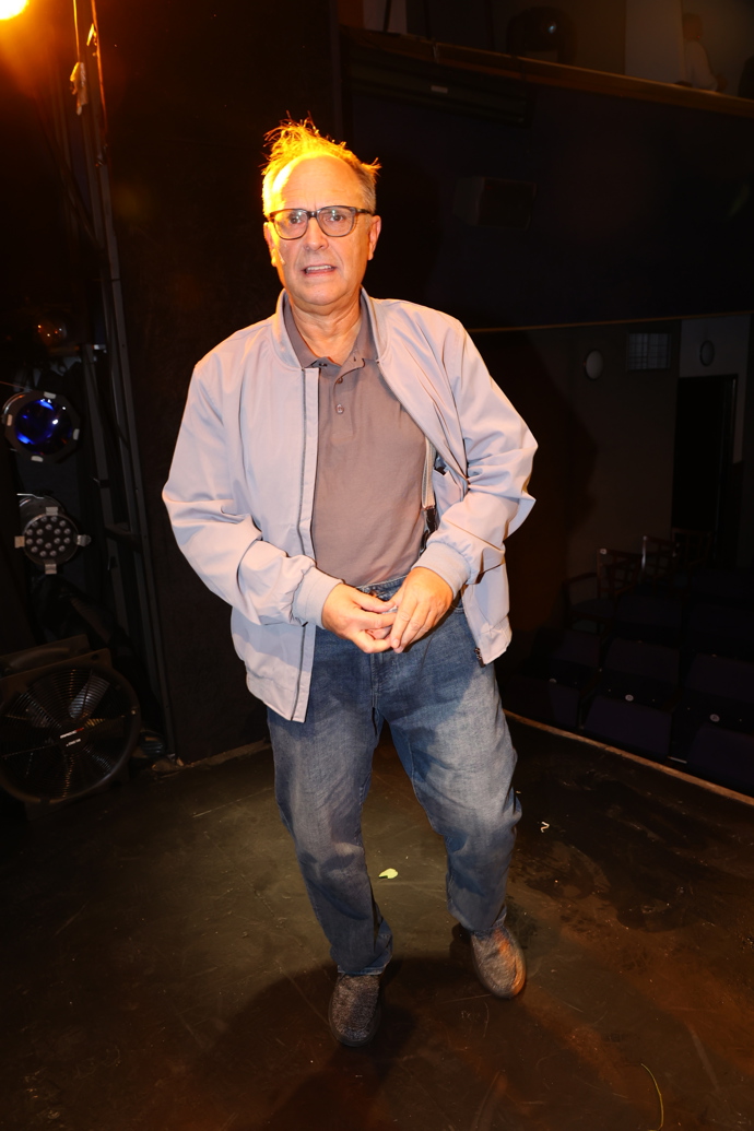 Na jevišti nosí pohodlné džíny a světle hnědé tričko. 