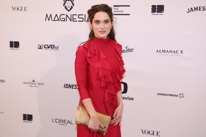 Herečka Judit Pecháček zase k výrazným červeným šatům od návrhářky Josefíny Bakošové nasadila šperky z dílny českého designéra Jakuba Líbala.