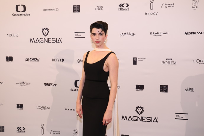 Herečka Antonie Martinec Formanová, vnučka legendárního režiséra Miloše Formana, svou minimalistickou černou róbu s kontrastní krémovou šálou z dílny Alexandry Gnidiak také doladila šperky z tvorby Janjy Prokić.
