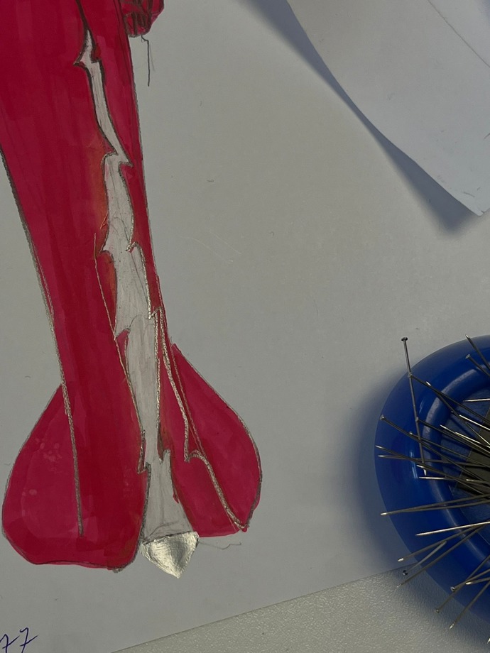 Šaty mají vysoký rozparek a návrhář k nim doporučil zlaté metalické lodičky s uzavřenou špičkou. 