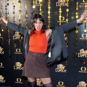 Luciana zazářila v oranžovém tričku, hnědé minisukni a silonkách s černým vzorem punčoch. 