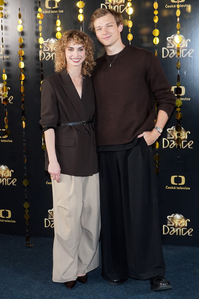 Tomas Sean Pšenička a Natálie Otáhalová. Natálie oblékla béžové široké kalhoty a hnědé sako na holém těle přepásané páskem. 