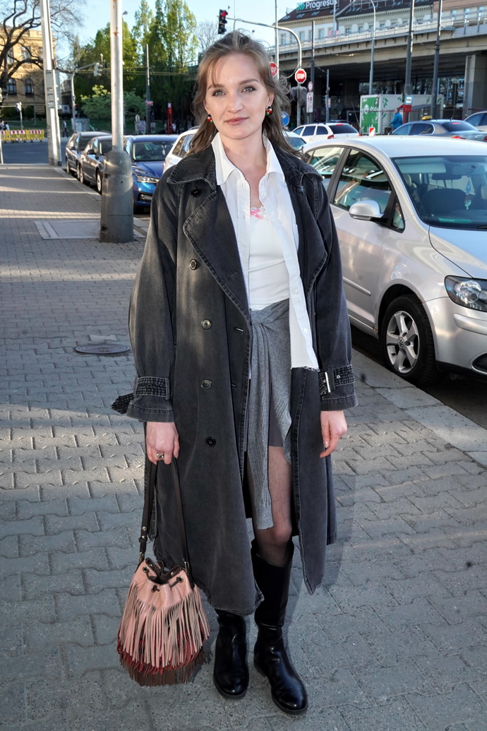 Karolína Šafránková oblékla dlouhý zimní kabát, pod něj bílou košili a šedou minisukni přepásanou šedým svetrem.