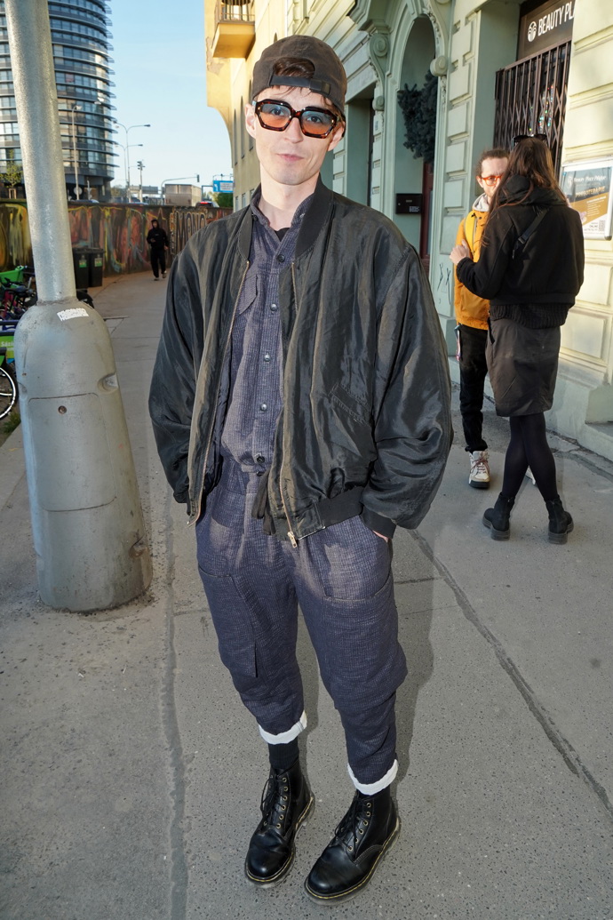 Denis Šafařík zvolil černou přechodovou bundu, k tomu tmavě modrou košili a tmavě modré kalhoty s ohrnutými nohavicemi.