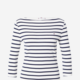 Zpoza košile vykukuje nenápadný, ale klíčový prvek, kterým je námořnické tričko. Proužky jsou nadčasové, ale letos se opět vrací do hry i jako trend. Toto provedení s lodičkovým výstřihem je od značky Tommy Hilfiger a vyjde vás na 1499 Kč.