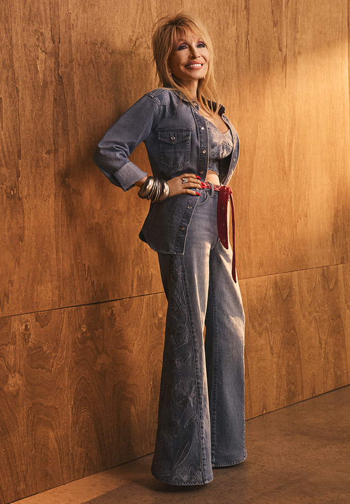 Široké džíny s decentní výšivkou Dolly Parton doplnila ladící bundičkou, crop topem a šátkem místo pásku.