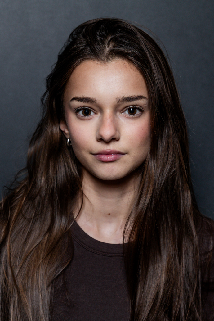 Mladá slečna má dlouhé kaštanově hnědé vlasy. 