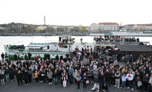 Smutný pohled na zástupy lidí u břehu Vltavy.