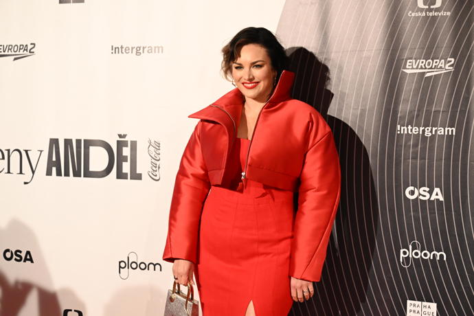 Korzetový top šatů zdobil krátký bomber. 