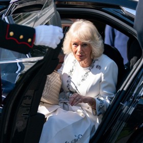 Královna Camilla vystupuje z vozu.