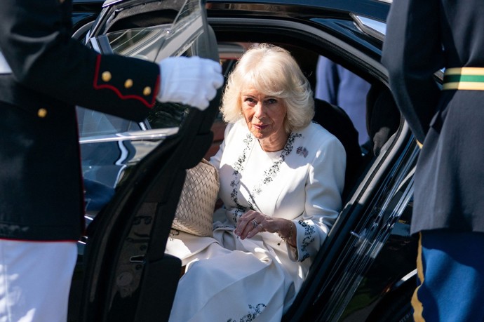 Královna Camilla vystupuje z vozu.